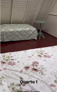 a bedroom with two beds with a floral bedspread at Cabana da Serra in Riozinho +9 photos