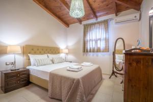 a bedroom with a bed with a dresser and a mirror at Fiorentinos Villa in Tragaki