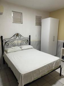 a bedroom with a bed and a white refrigerator at Casa Harmonia in Trairi