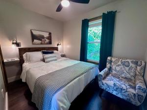 a bedroom with a bed and a chair and a window at By the Docks Knox in Knoxville