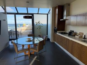 a kitchen and dining room with a table and chairs at The Ocean View Guest House in Wilderness