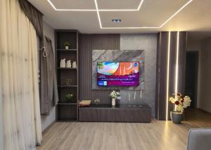 a living room with a tv on a wall at كمبوند العالمية in Madinat Al Ashir min Ramadan