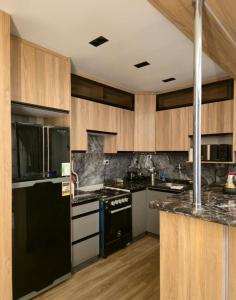 a kitchen with black appliances and wooden cabinets at كمبوند العالمية in Madinat Al Ashir min Ramadan +3 photos