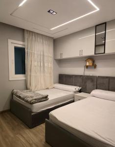 a small bedroom with two beds and a window at كمبوند العالمية in Madinat Al Ashir min Ramadan