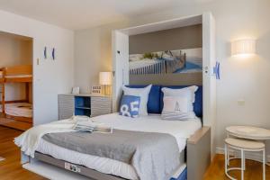 a bedroom with a large bed with blue and white pillows at Résidence Pierre & Vacances La Baie des Sables in Les Sables-d'Olonne