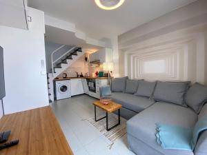 a living room with a couch and a table at PLAYMAR Refugio Palmeras in Maspalomas