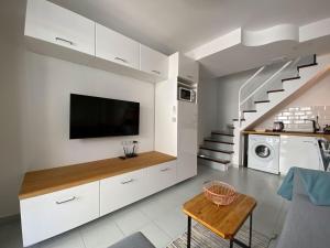 a living room with a tv on a wall at PLAYMAR Refugio Palmeras in Maspalomas