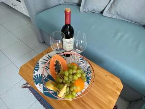 a table with a plate of fruit and a bottle of wine at PLAYMAR Refugio Palmeras in Maspalomas