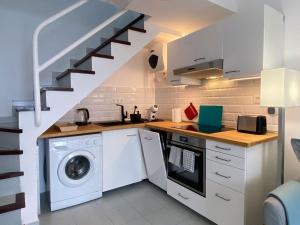 a kitchen with a washing machine and a staircase at PLAYMAR Refugio Palmeras in Maspalomas +12 photos