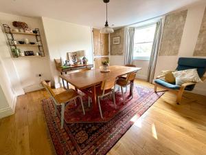 a dining room with a table and a couch at Widgeons Keel in Falmouth