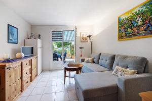 a living room with a couch and a tv at Maison La Parée Plage in Bretignolles-sur-Mer