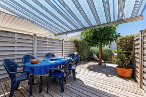 a blue table and chairs on a wooden deck at Maison La Parée Plage in Bretignolles-sur-Mer