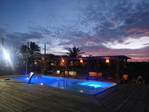 a swimming pool at night with a restaurant at Pousada rancho sol nascente in Tutóia