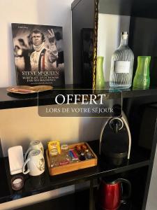 a shelf with a sign that saysoffer and a bottle at KVS concept Écommoy chambres haut de gamme proche circuit 24 heures Le Mans in Écommoy