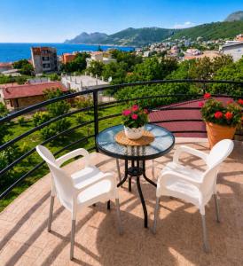 a table and chairs on a balcony with a view at Apartments Taida in Dobra Voda
