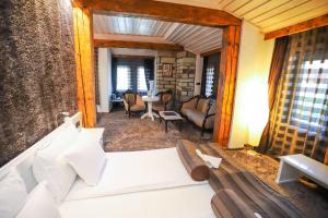 a bedroom with a couch and a living room at Old House Glavatarski Han in Glavatartsi