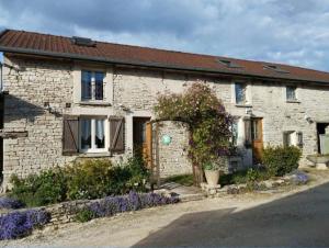 a brick house with flowers in front of it at La clémenceraie in Baroville