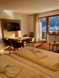 a hotel room with a bed and a table and chairs at Sporthotel Walliser in Hirschegg +202 photos