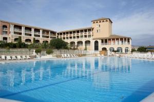 a large swimming pool in front of a building at Cap Estérel by Actisource in Agay - Saint Raphael