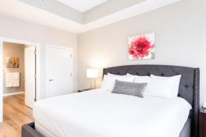 a white bedroom with a large bed with white pillows at Luxury Apartment In Harbor Point in Stamford