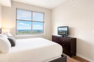a bedroom with a bed and a tv and a window at Luxury Apartment In Harbor Point in Stamford