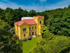 an aerial view of a yellow house with a red roof at Zámeček Rozkoš in Střížovice