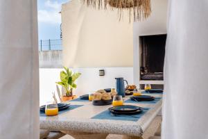 a dining room table with blue plates and orange juice at Casa Leonor, stunning 3 bedroom villa in Carvoeiro in Praia do Carvoeiro