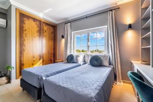 two beds in a room with a window at Casa Leonor, stunning 3 bedroom villa in Carvoeiro in Praia do Carvoeiro +29 photos