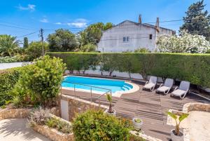 a backyard with a swimming pool and chairs and a house at Casa Leonor, stunning 3 bedroom villa in Carvoeiro in Praia do Carvoeiro