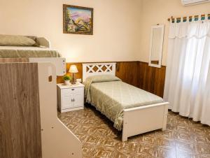 a small bedroom with a bed and a small table at El Indio - Casa de Campo con Piscina y Parrilla in Villa del Salvador