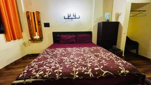 a bedroom with a bed with a purple comforter at guest house carolina in Colva