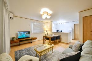 a living room with a couch and a table at 北谷町港1 in Chatan