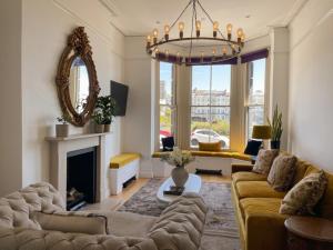 a living room with a couch and a chandelier at Hastings House 9-Bedroom Holiday House in Hastings