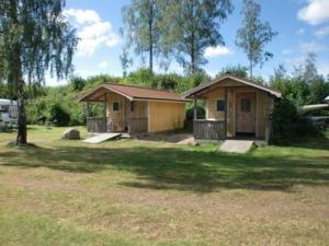 a small house in a yard with a tree at Sommens Camping in Sommen