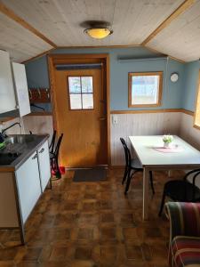 a kitchen and dining room with a table and chairs at Sommens Camping in Sommen