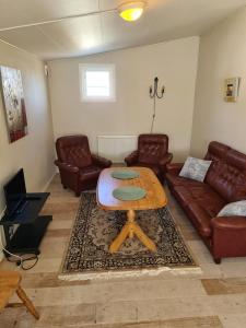 a living room with a table and leather furniture at Sommens Camping in Sommen +12 photos