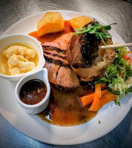 a plate of food with meat and vegetables on a table at The Wigtown Ploughman in Wigtown