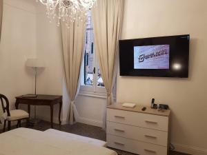 a bedroom with a dresser and a tv on the wall at VarazzeSuite Sauna e Hammam in Varazze