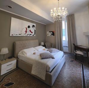 a bedroom with a large bed and a chandelier at VarazzeSuite Sauna e Hammam in Varazze