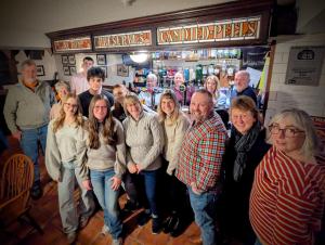 a group of people standing in front of a bar at The Wigtown Ploughman in Wigtown