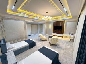 a large room with two beds and a television at ASR Plaza in Jizzax