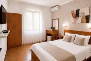 a hotel room with a bed and a television at Apartments Taida in Dobra Voda