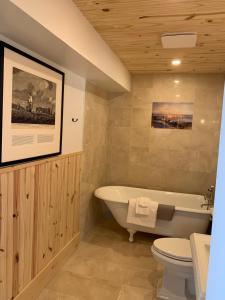 a bathroom with a bath tub and a toilet at Au Pic de l'Aurore Motel-Chalets in Perce +185 photos