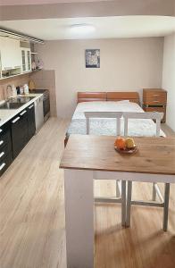 a kitchen with a table with a bowl of fruit on it at G - Apartments in Kumanovo