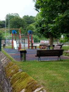 a park with a park bench and a playground at Apartamento El Ferial in Sarón