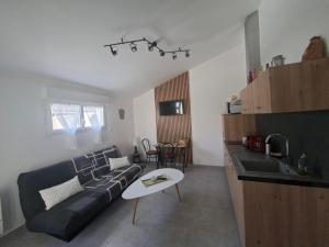 a living room with a blue couch and a kitchen at Bienvenue en Provence in Monteux