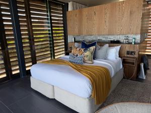 a bedroom with a large bed with pillows on it at The Ocean View Guest House in Wilderness +26 photos