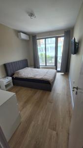 a bedroom with a bed and a large window at CIty view apartment in Gotse Delchev