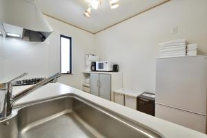 a kitchen with a stainless steel sink and appliances at 北谷町港1 in Chatan +69 photos