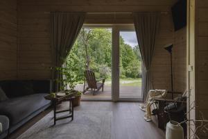 a living room with a couch and a sliding glass door at Obuoliu sala Moletu Vila in Gaylyunay